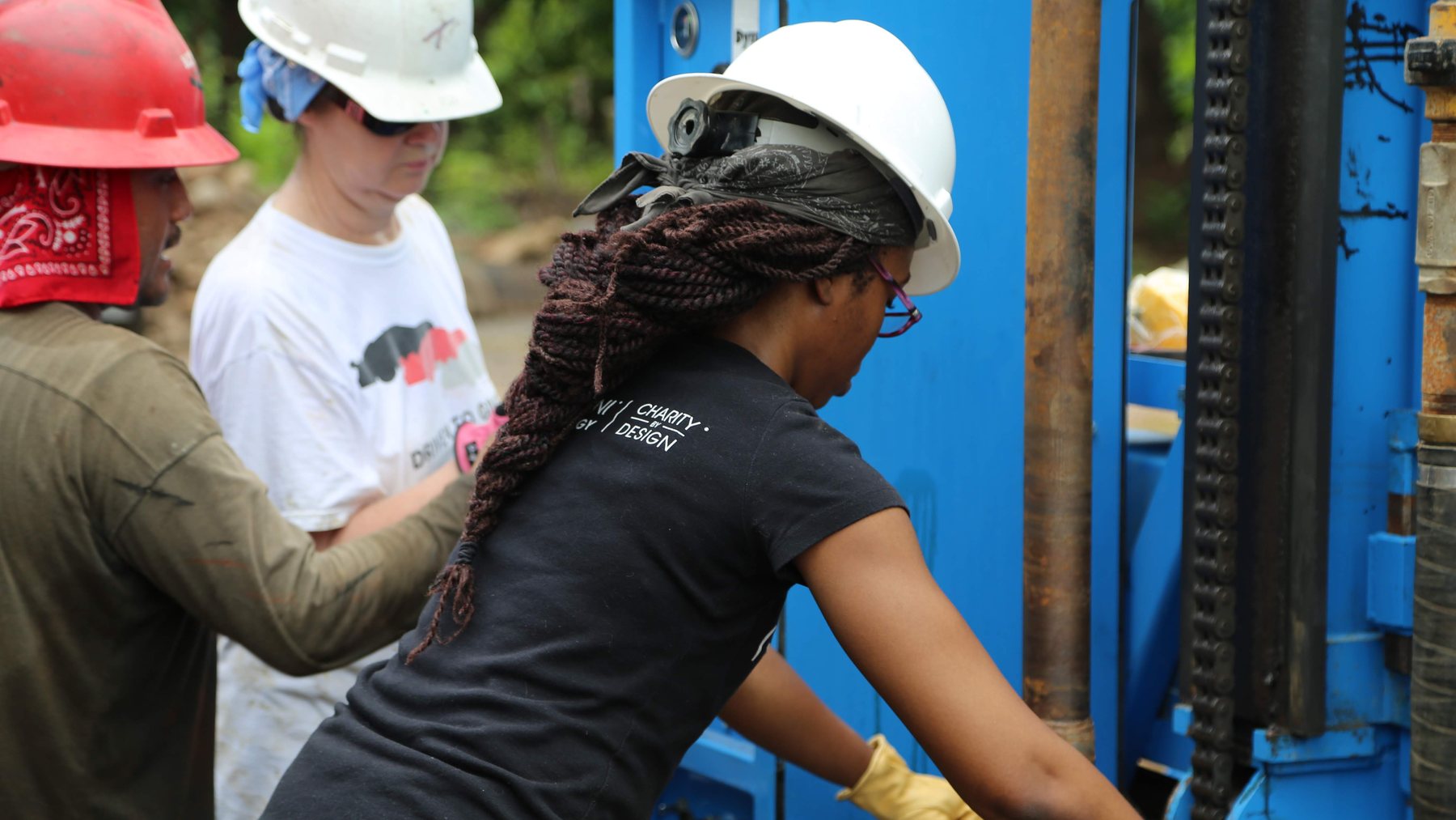 Deidre Osei operating a well-drilling rig on a clean water project with the Charity by Design team